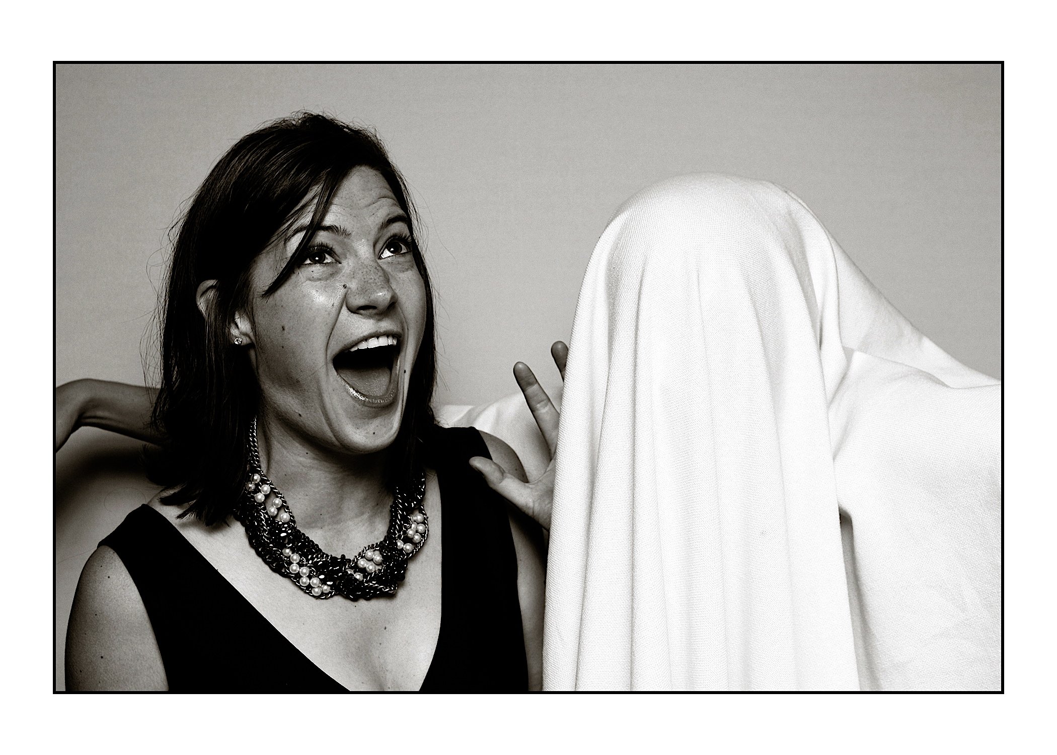 Liz Sower yelling and laughing at the same time, being attached by someone in a white bedsheet.