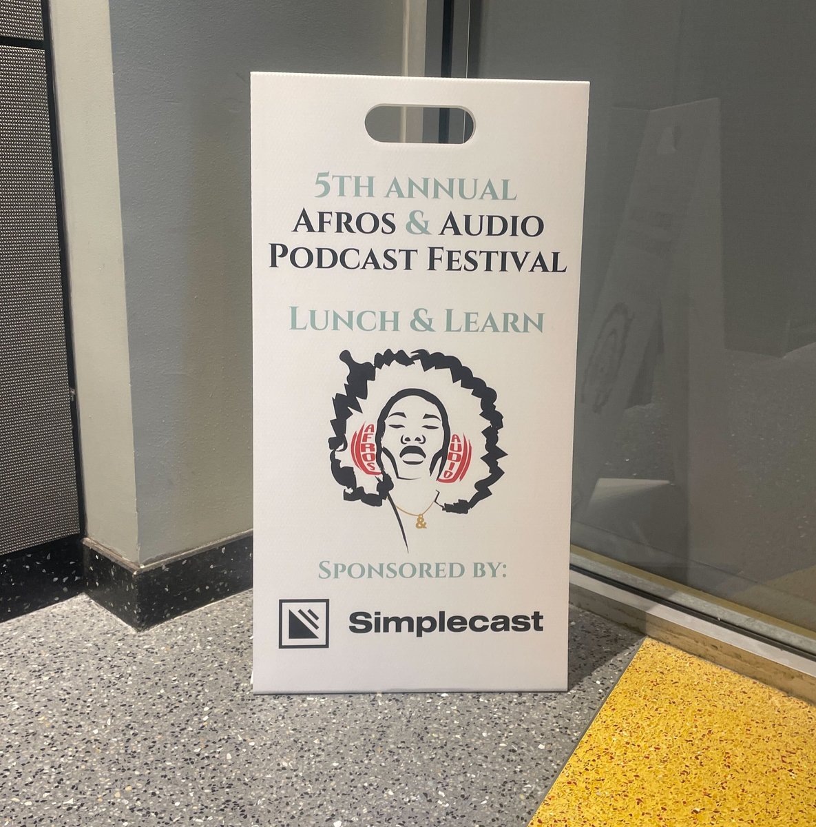A sign at Afros & Audio that says: 5th Annual Afros & Audio Podcast Festival Lunch and Learn. Sponsored by Simplecast.