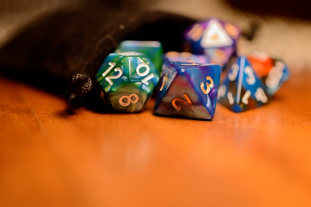 A d8,d12, and d4 on a table; more dice blurred in the background.